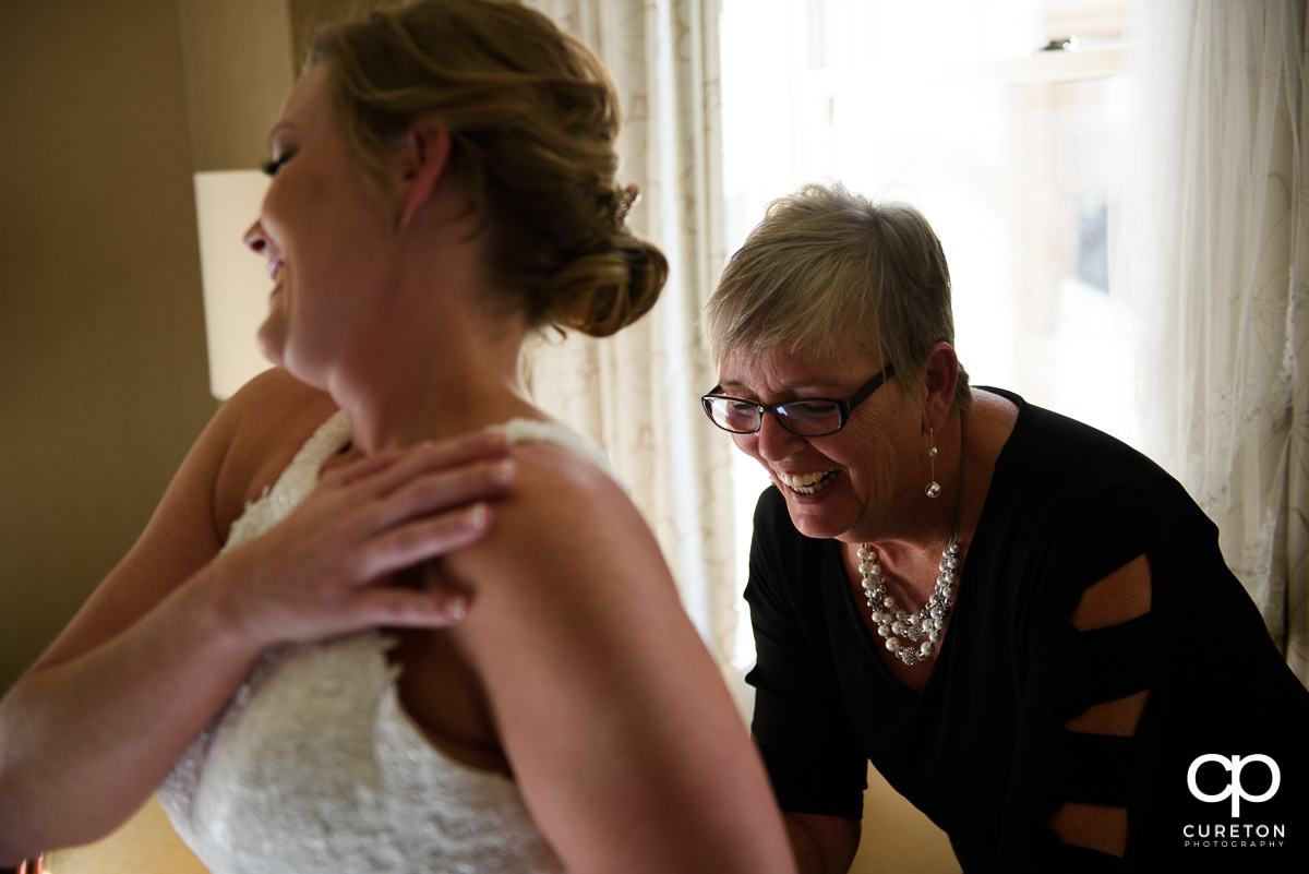Bride's mother helping her in to the dress.