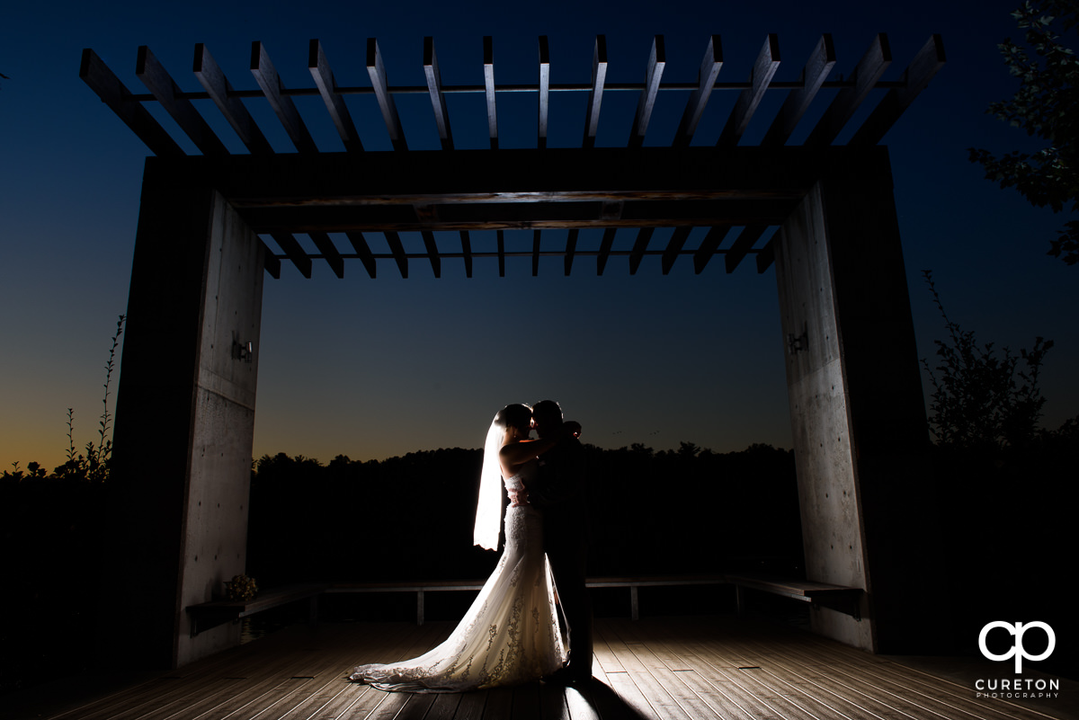 Bride and groom silhouette by the lake at Furman.