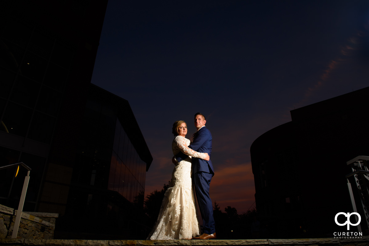 Bride and groom standing at the top of the steps an sunset during their wedding reception at Larkin's Cabaret Room.