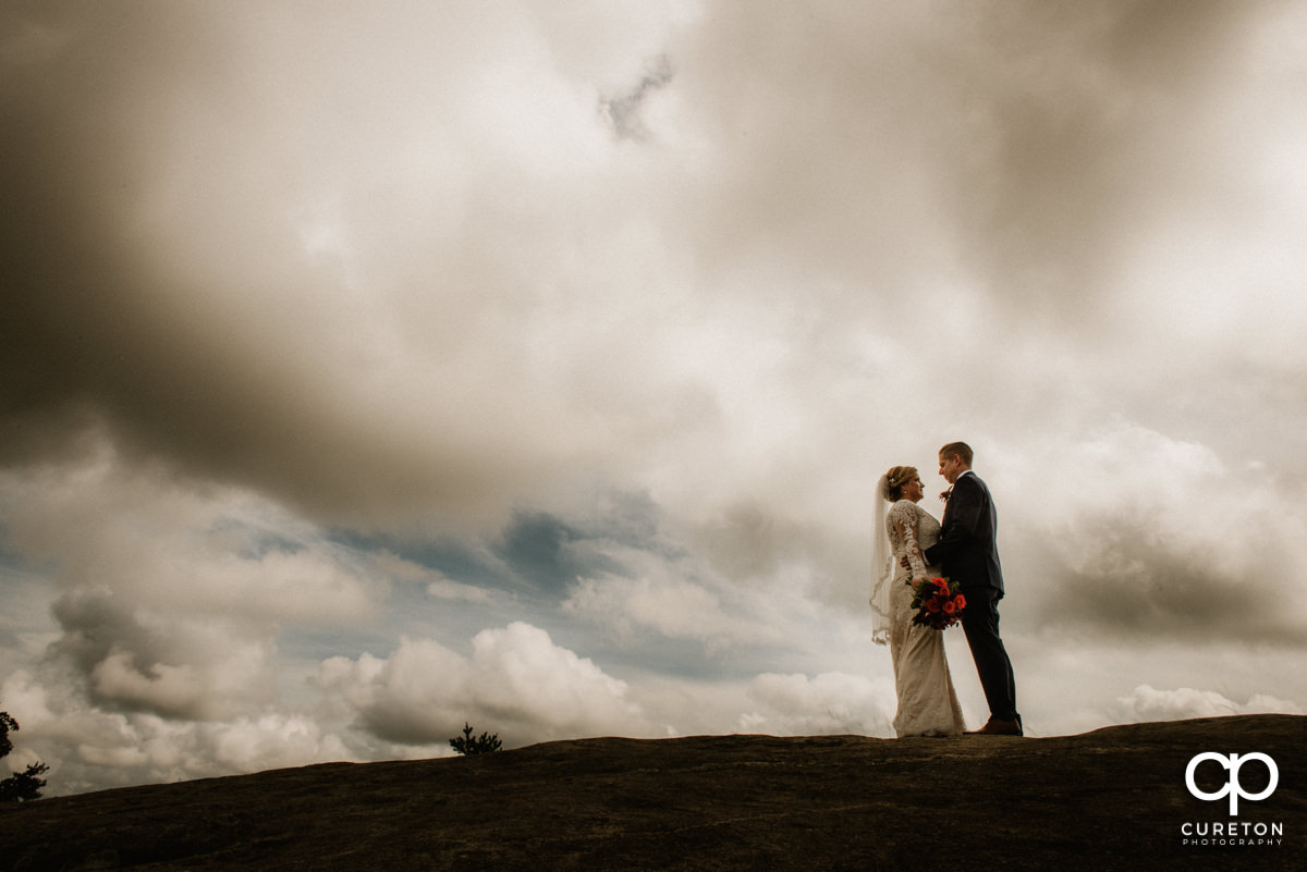 Bride and groom on top of the rock at Glassy Chapel after their wedding ceremony.