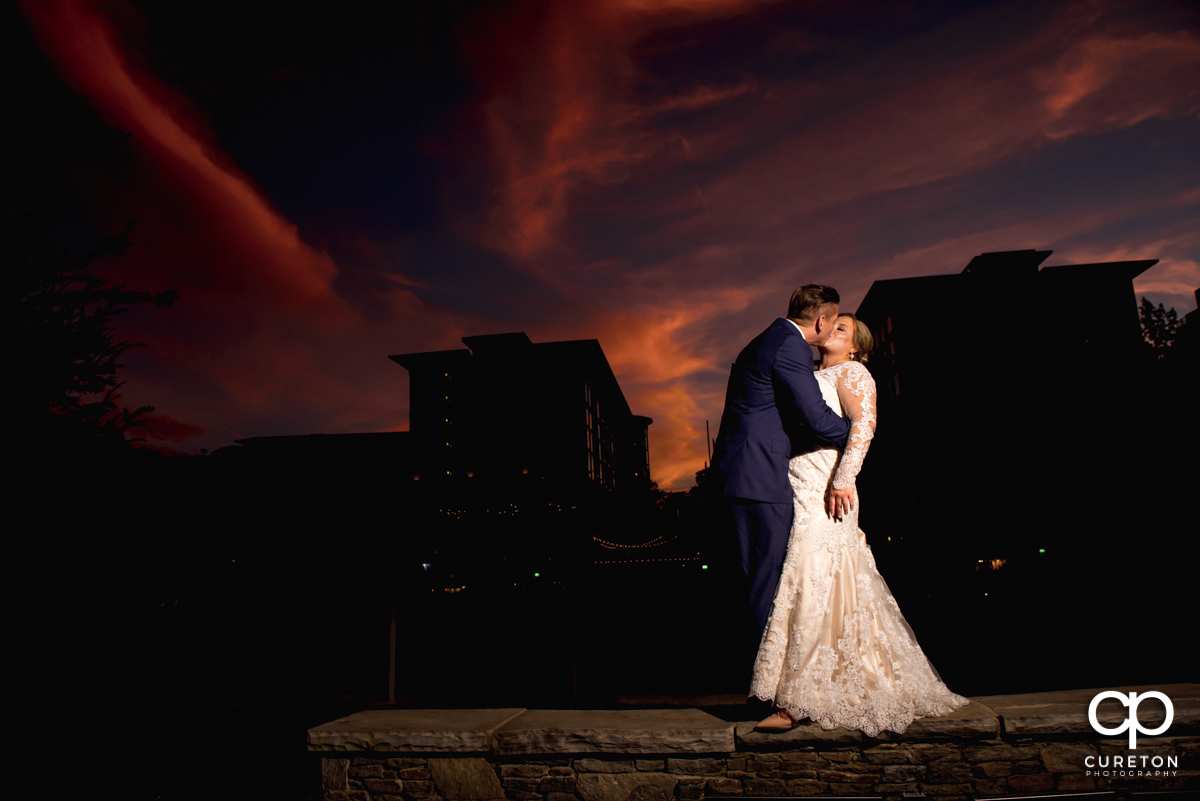 Bride and groom kissing at sunset in downtown Greenville,SC at their wedding reception at Larkin's Cabaret Room.