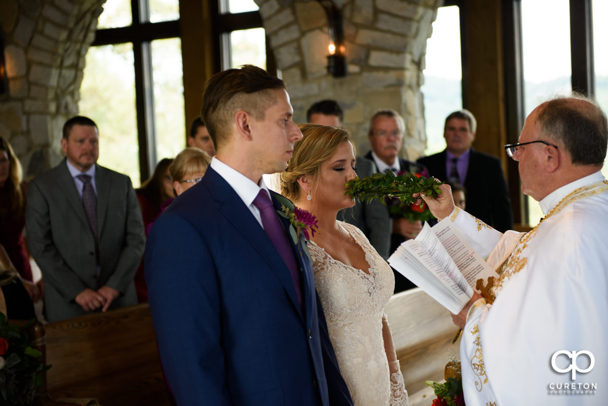 Bride kissing a floral crown at the wedding ceremony.