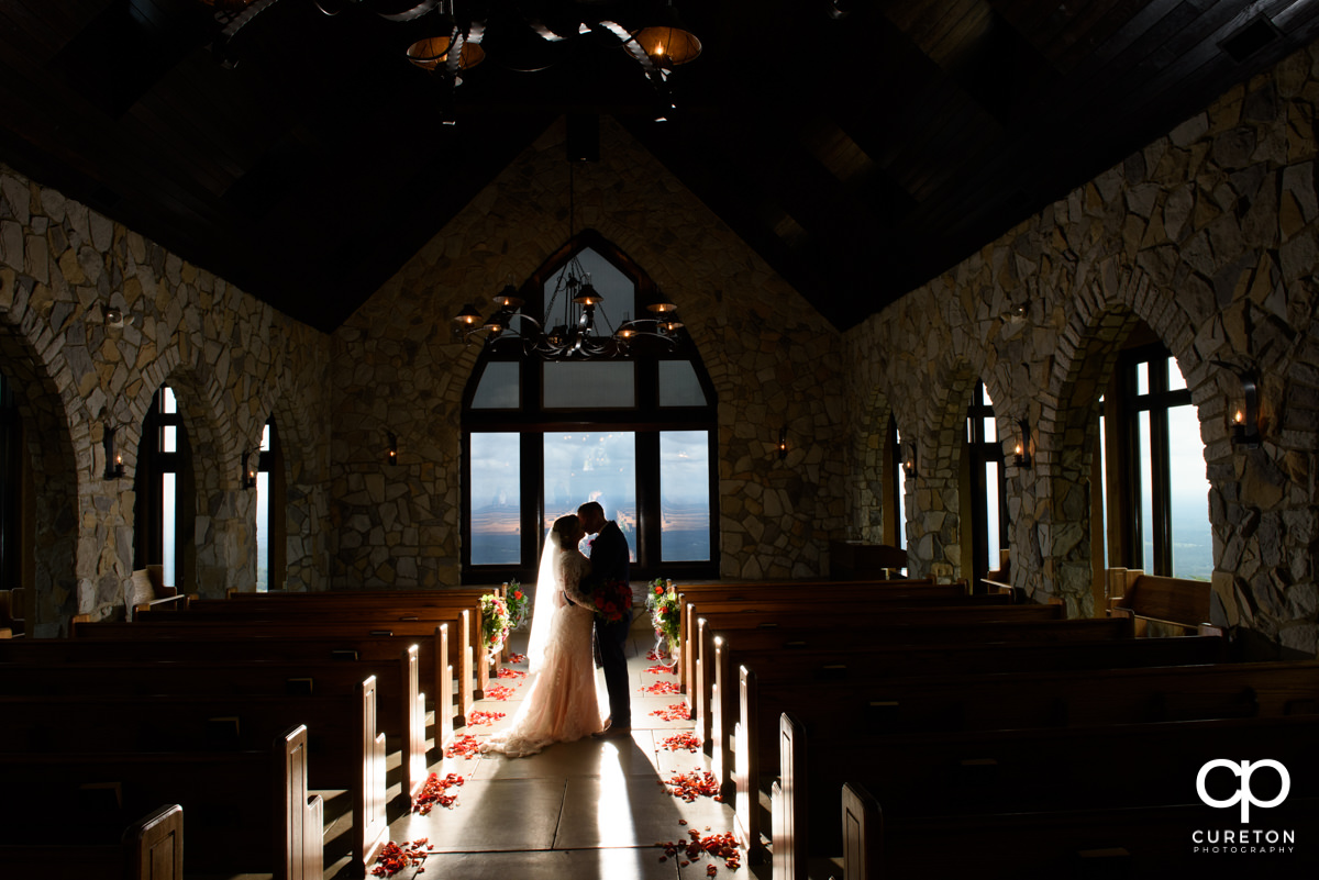 Bride and groom silhouette of them kissing inside Glassy Chapel after the wedding ceremony.