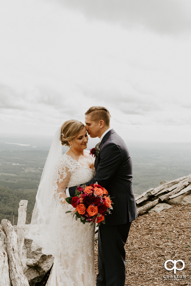 Bride and groom standing on a cliff at Glassy Chapel.