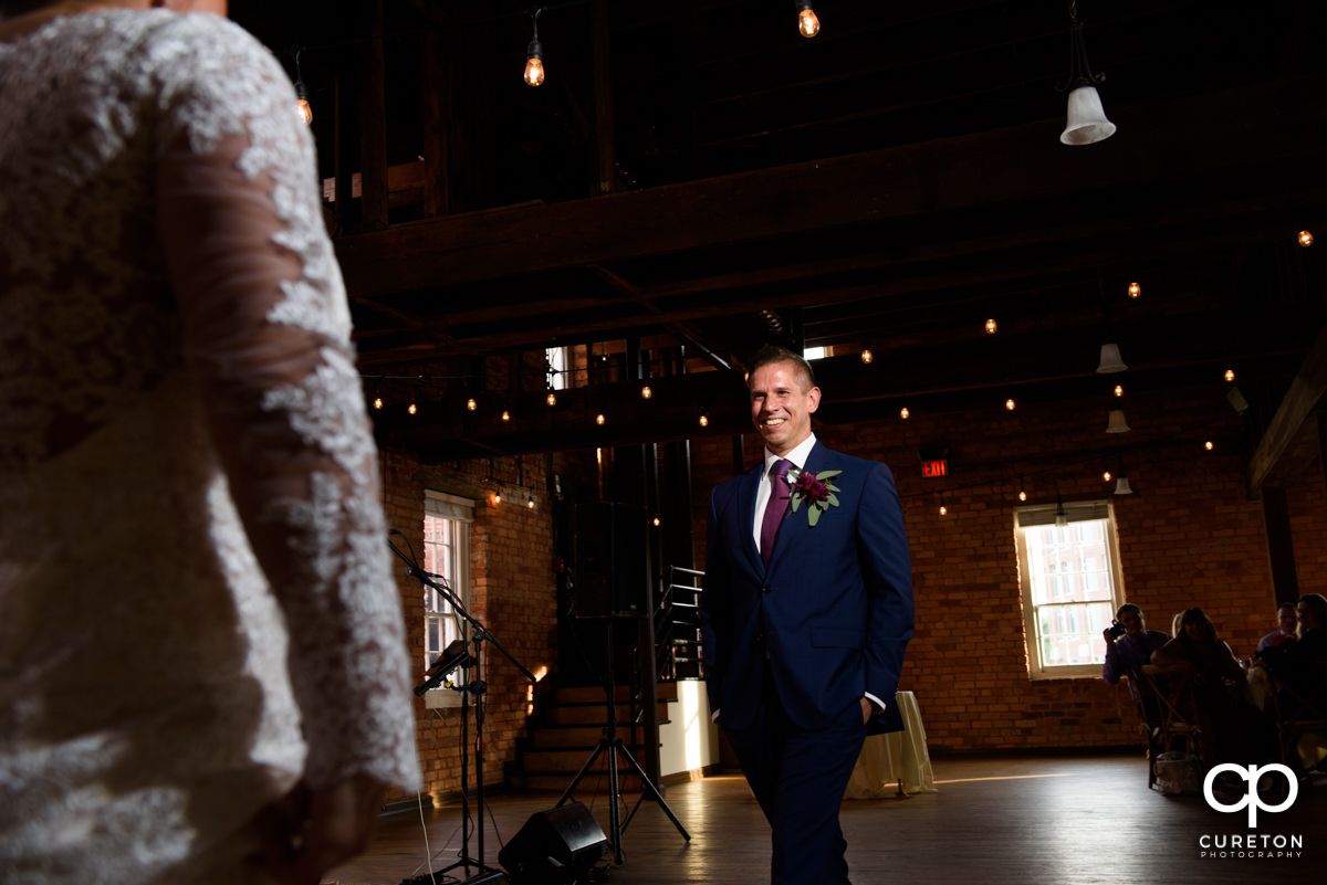 Groom looking at the bride at their first dance.