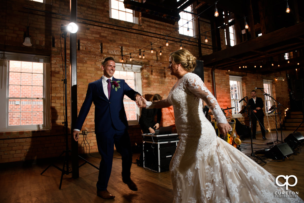 Bride and groom smiling during their first dance at their Larkin's Cabaret Room wedding reception in downtown Greenville,SC.