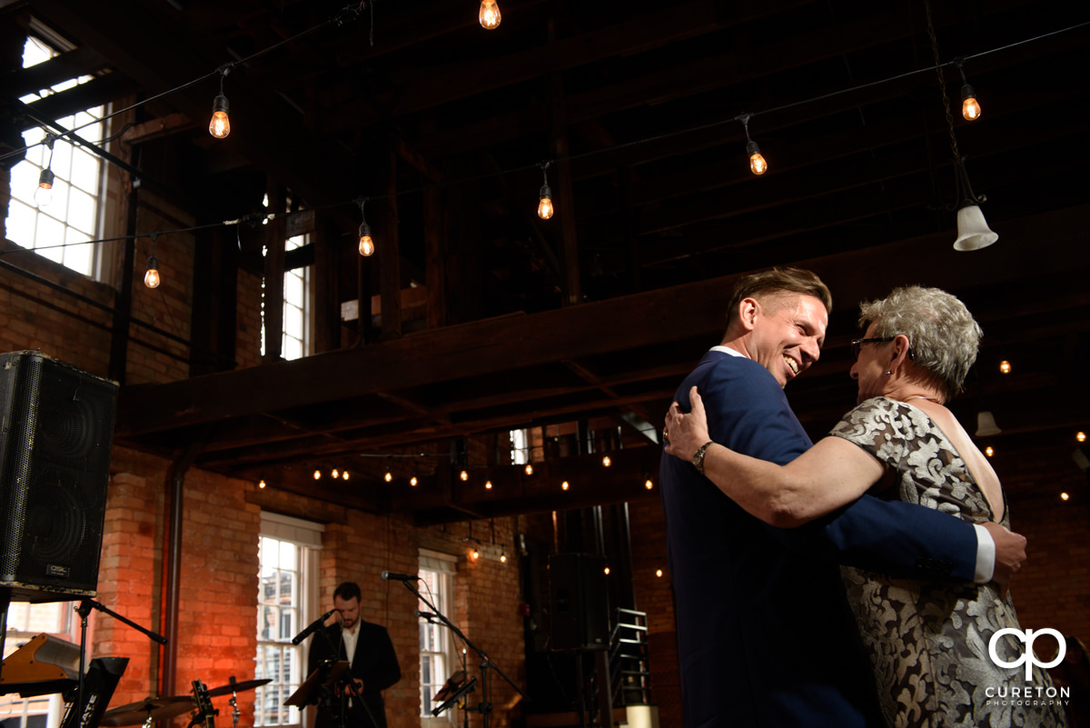 Groom smiling at his mother as they share a dance at the wedding reception at Larkin's.