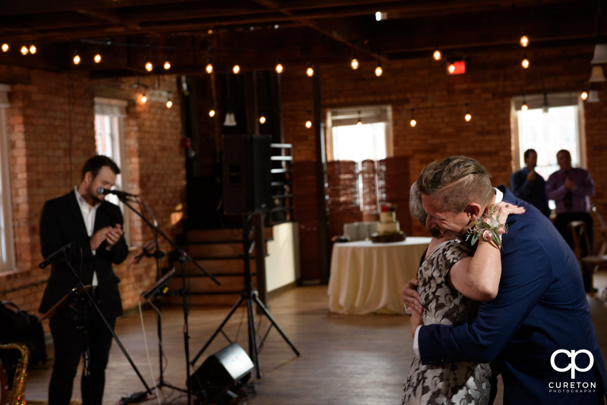 Groom hugging his mom at the reception.