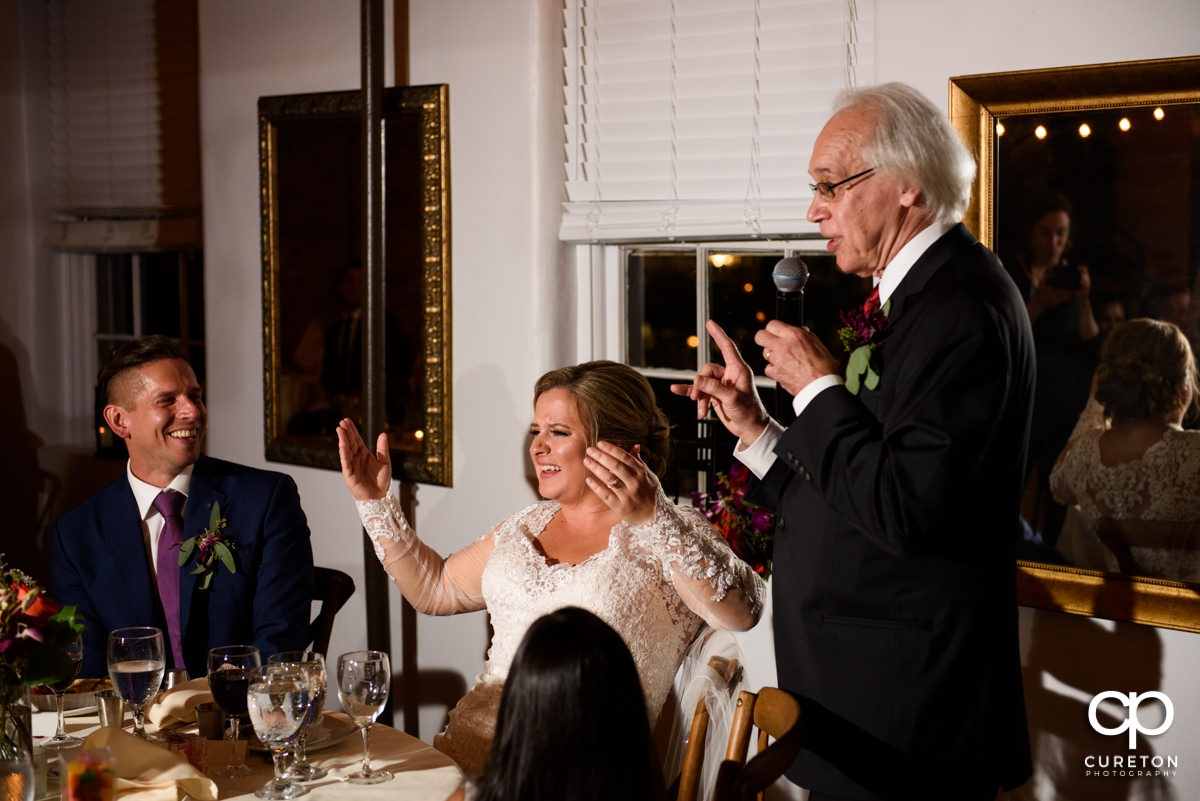 Groom's father giving a toast at the wedding reception.