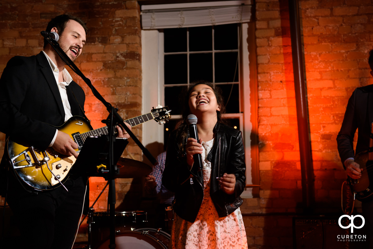 Little girl singing with the band at the wedding reception.