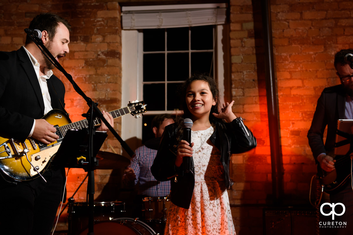 Little girl singing with the band at the wedding reception.