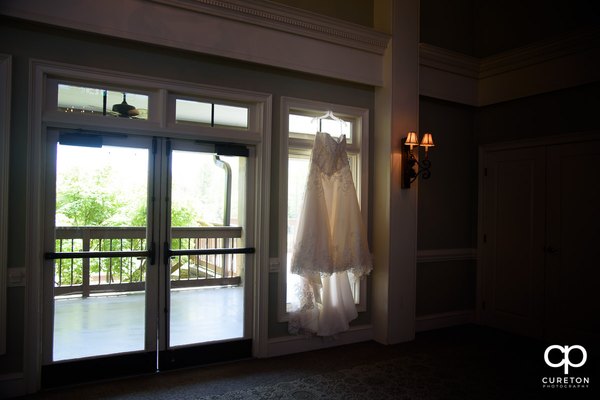 Bride's dress hanging in a window.