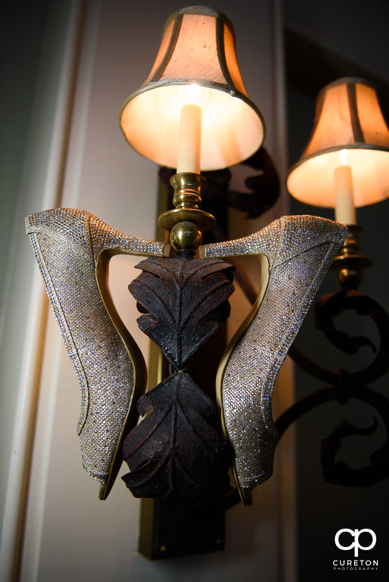 Bride's shoes hanging on a light fixture.