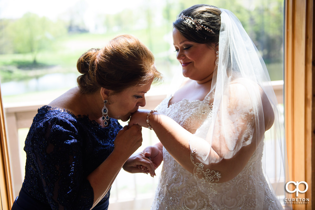 Bride's mom kissing her hand.