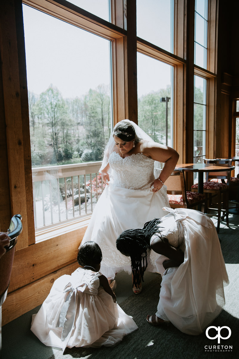 Bride being helped into her shoes.