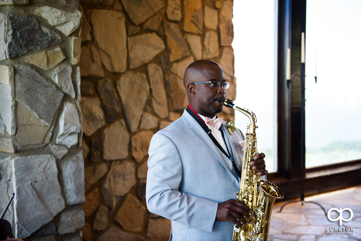 Groom playing the saxophone at the ceremony.
