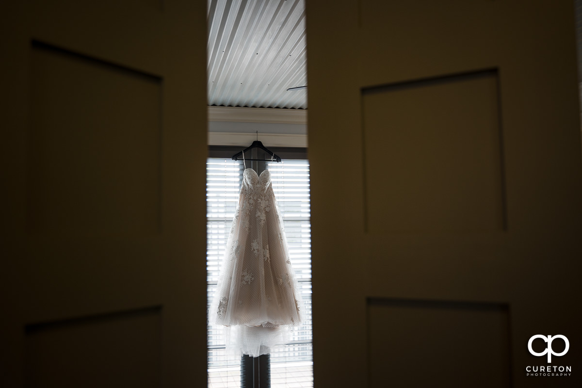 Bride's dress as seen peeking through doors opening.