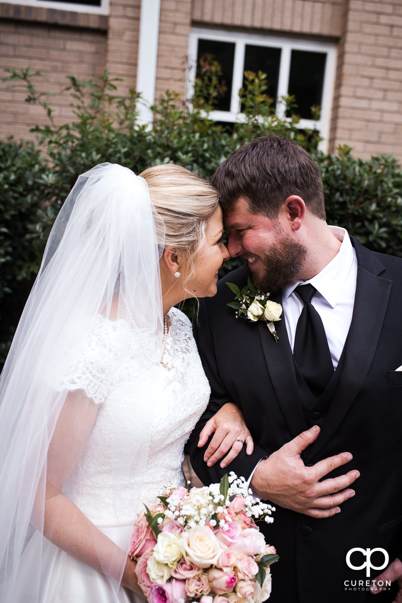 Bride and groom nose to nose after their church wedding.