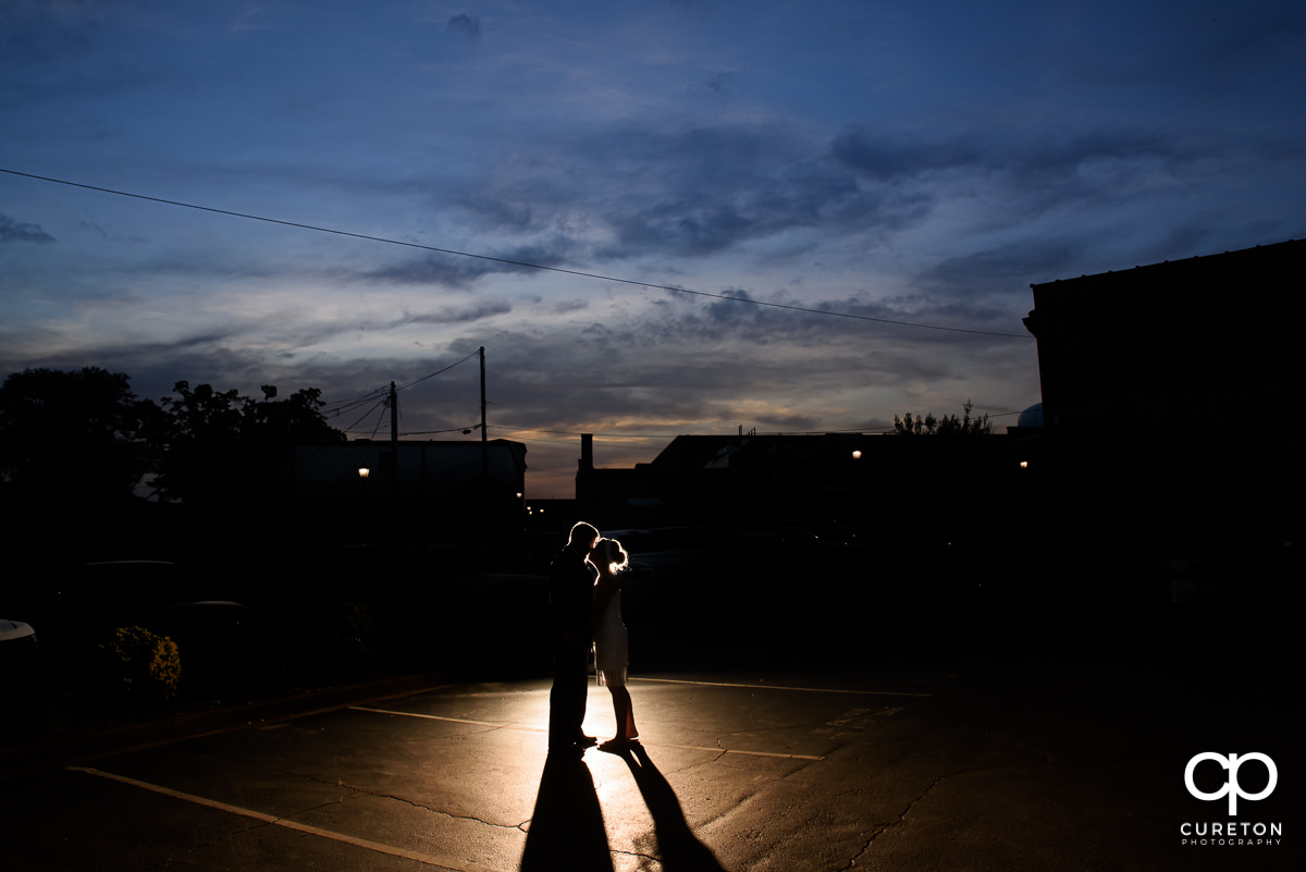 Bride and groom kissing at sunset outside of their Grace Hall wedding reception in Greer, SC.