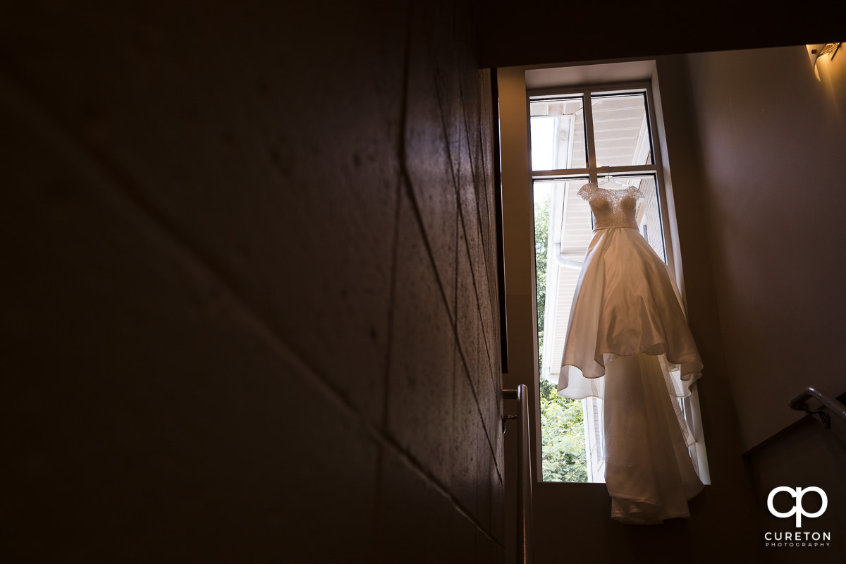 Bride's dress hanging in a church window.