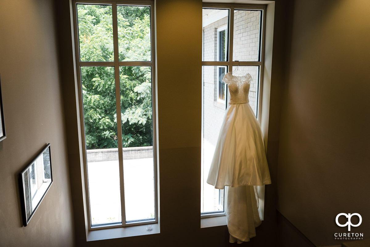 Bride's dress hangin in a church window.