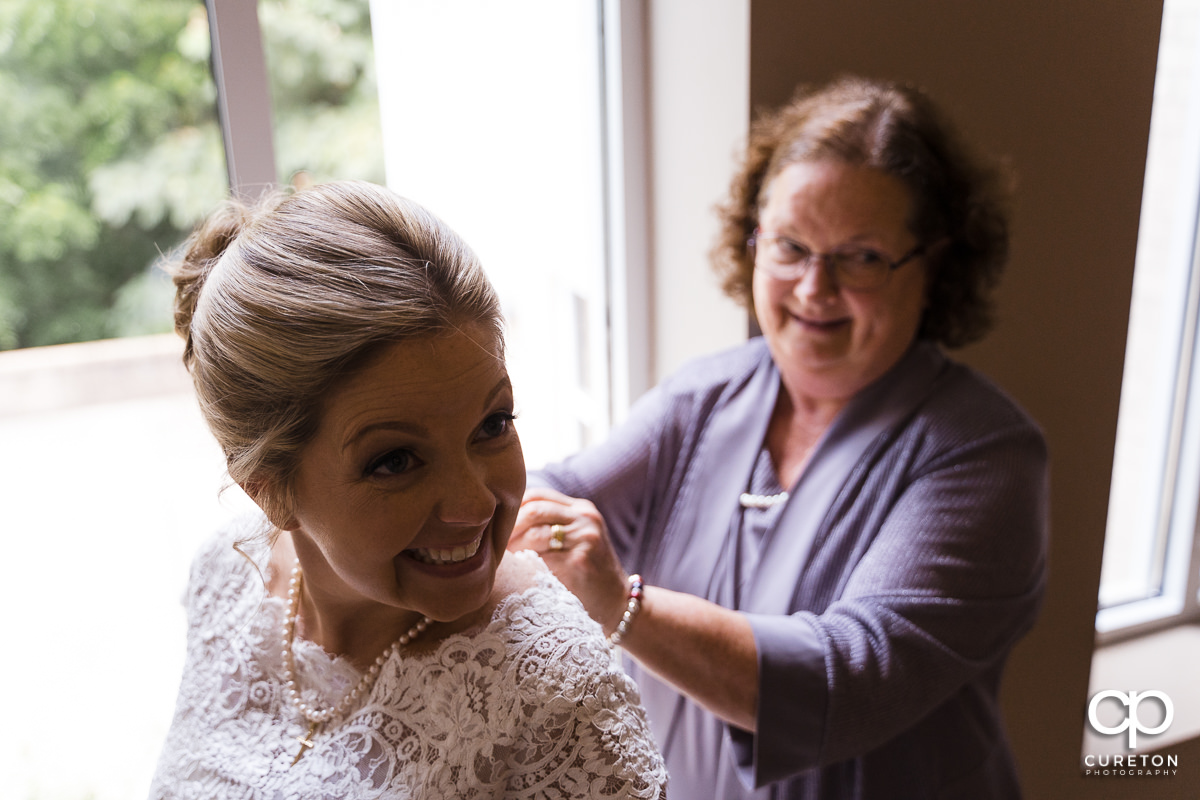 Bride being helped in to her dress.