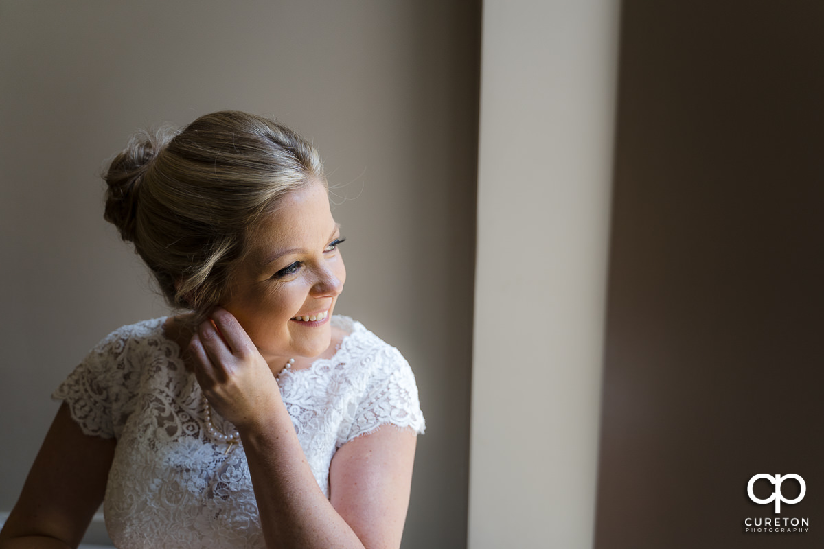 Bride putting in earrings.