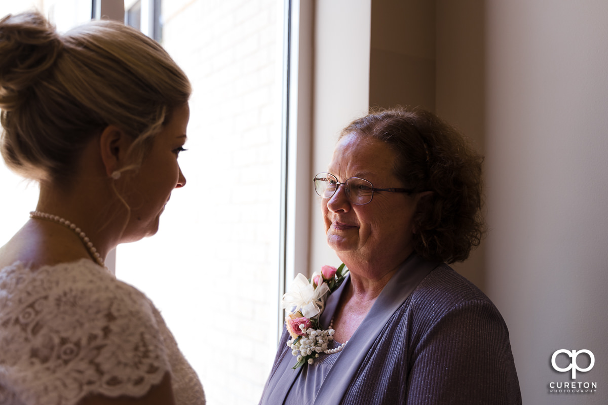 Bride's mom tearing up seeing her daughter in her dress.