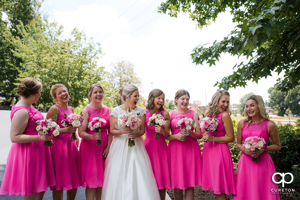 Bride and bridesmaids laughing.