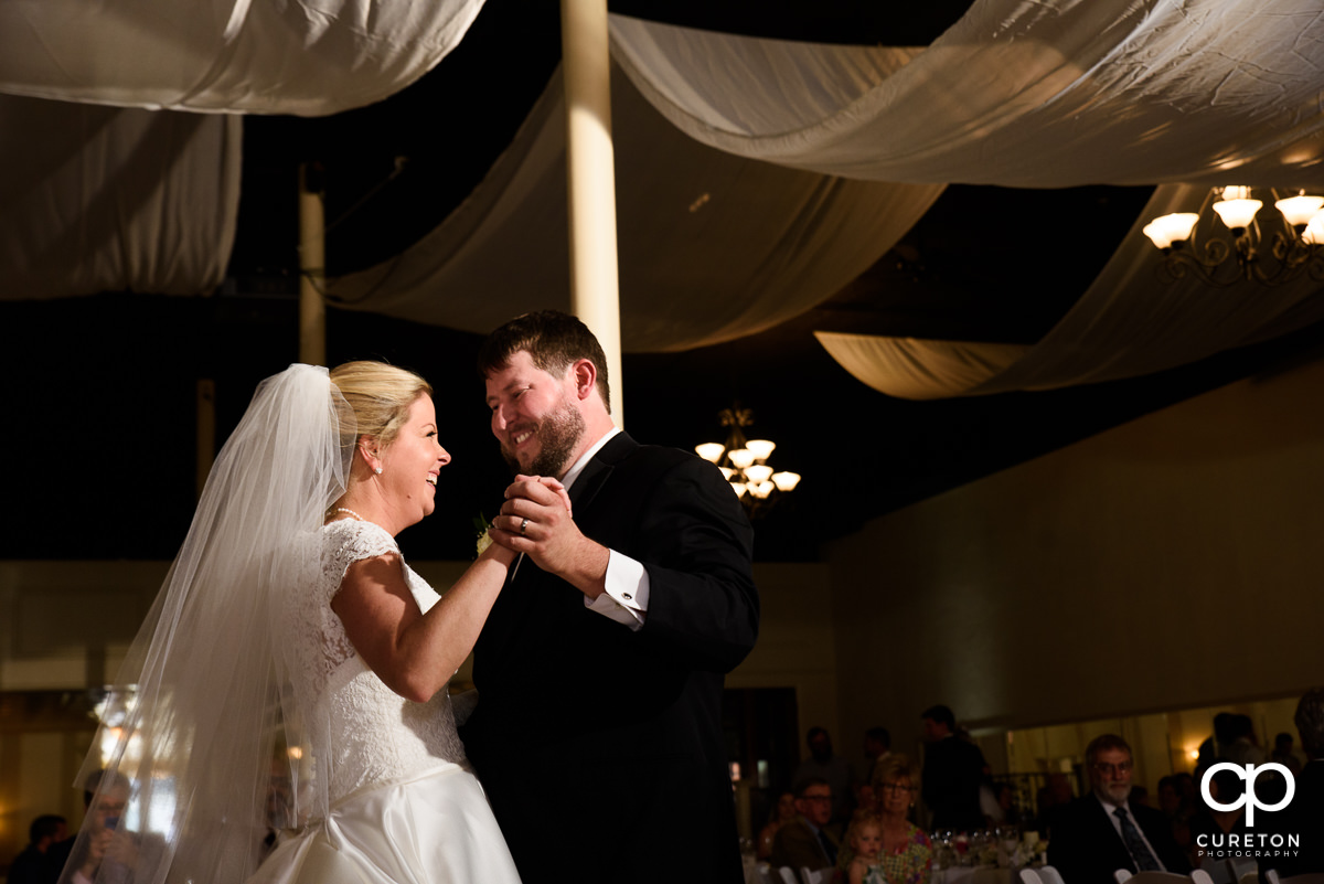 Groom smiling at his bride as they share a first dance at their Grace Hall wedding reception in downtown Greer,SC.