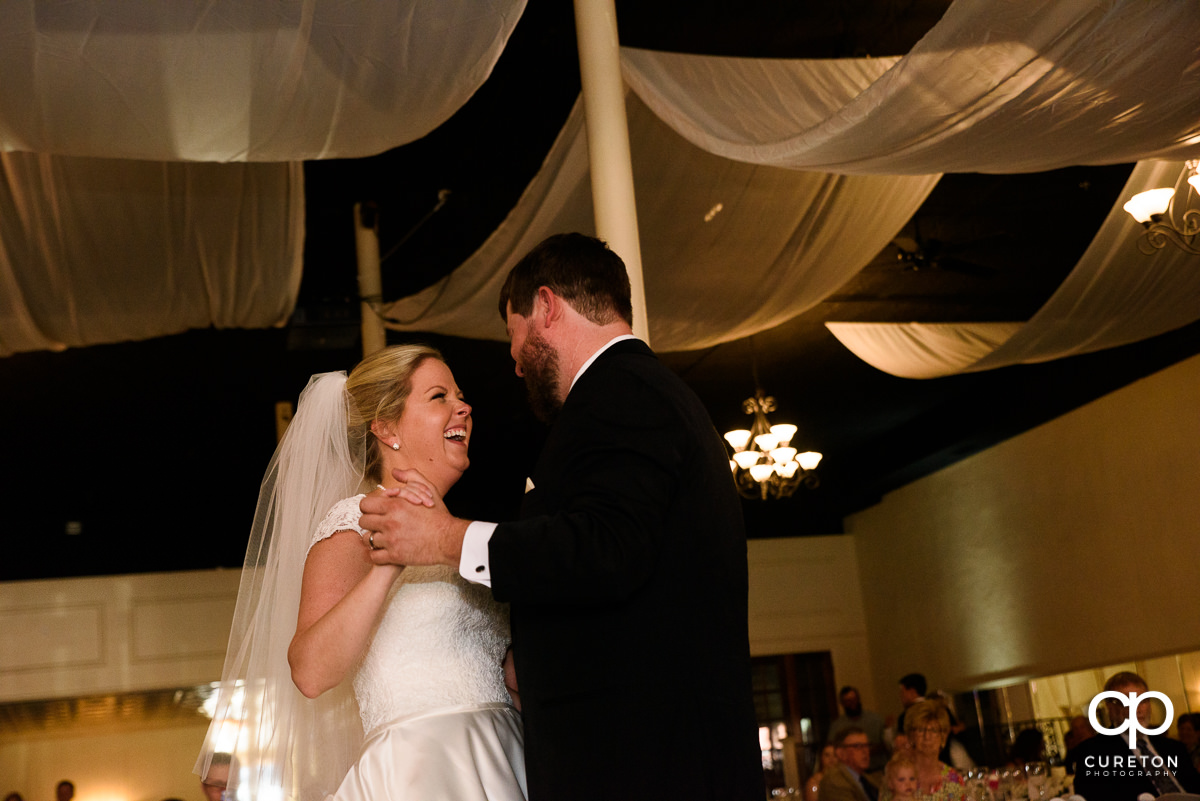 Bride laughing during their first dance at their Grace Hall wedding reception in downtown Greer,SC.