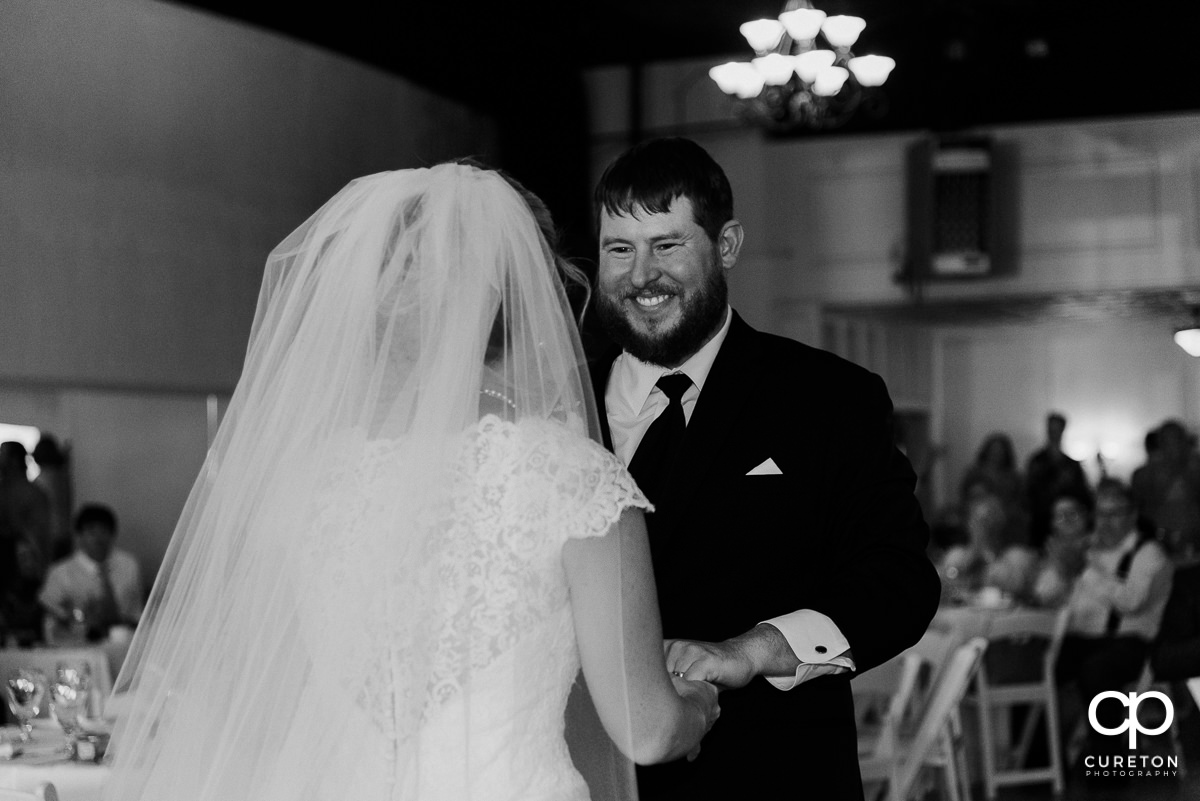 Groom smiling at his bride during a first dance at their Grace Hall wedding reception in downtown Greer,SC.