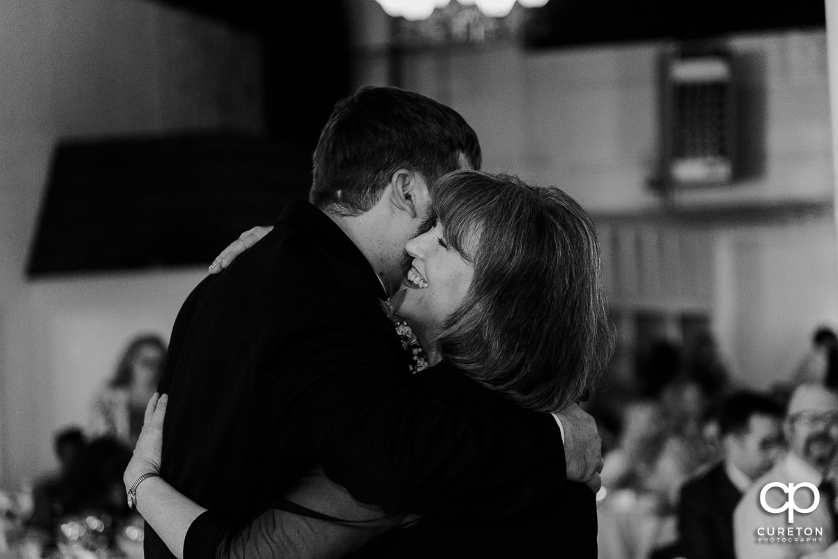 Groom hugging his mother at the wedding reception.