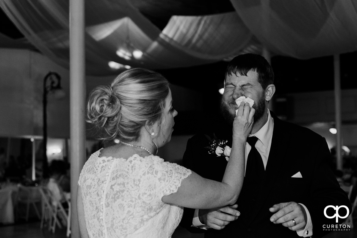 Bride wiping cake off of the groom's face.