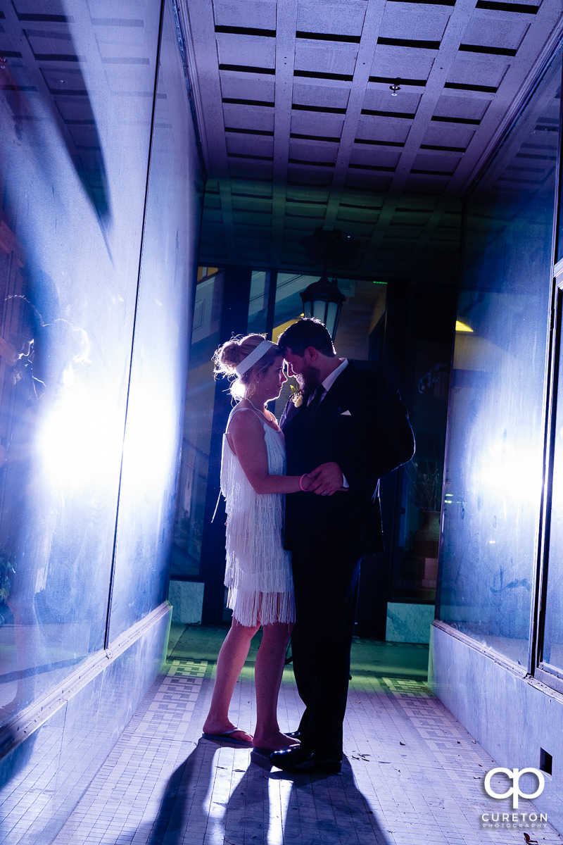 Bride and groom in a glass hallway in downtown Greer,SC after their wedding reception.
