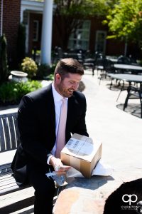 Groom opening up his gift from the bride.