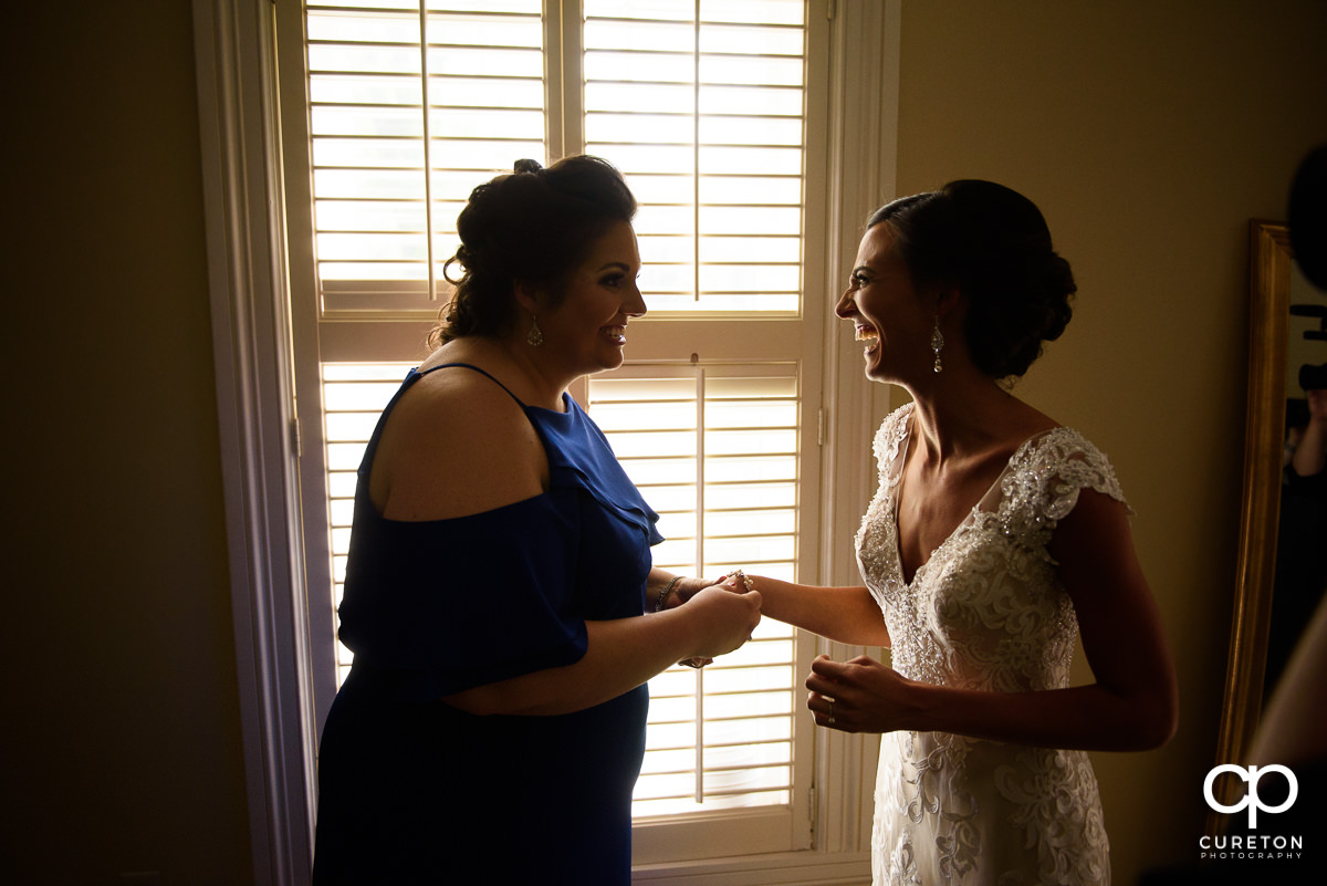 Bride laughing with her maid of honor.