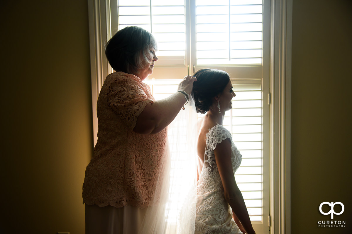 Bride's mother putting in her veil before the ceremony.