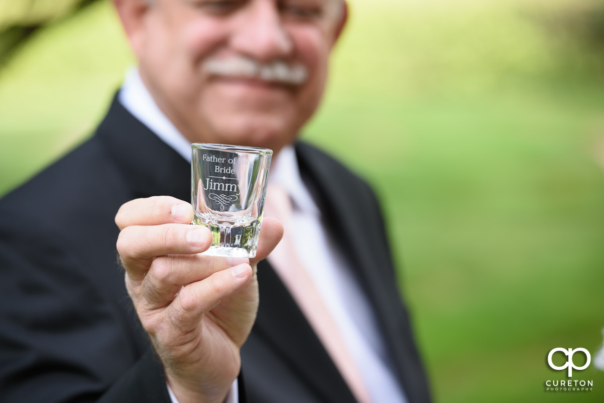 Father of the bride holding a personalized shot glass.