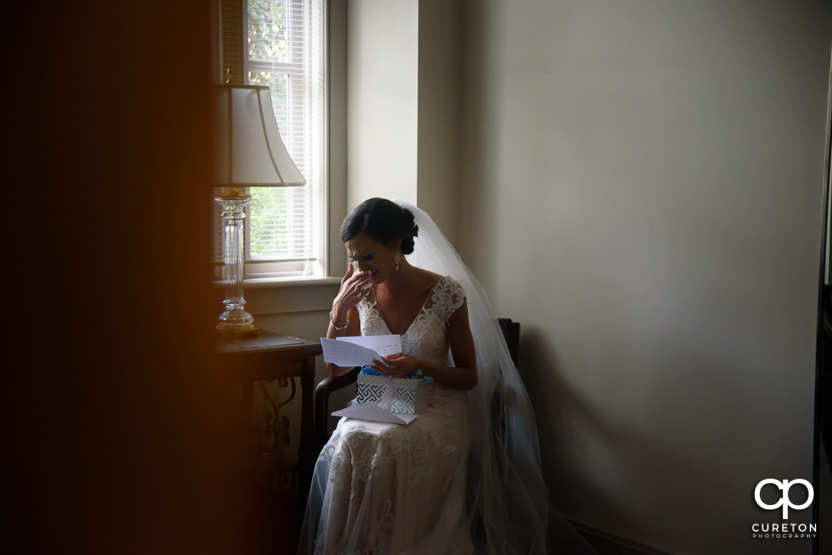 Bride tearing up while reading a letter from her groom.