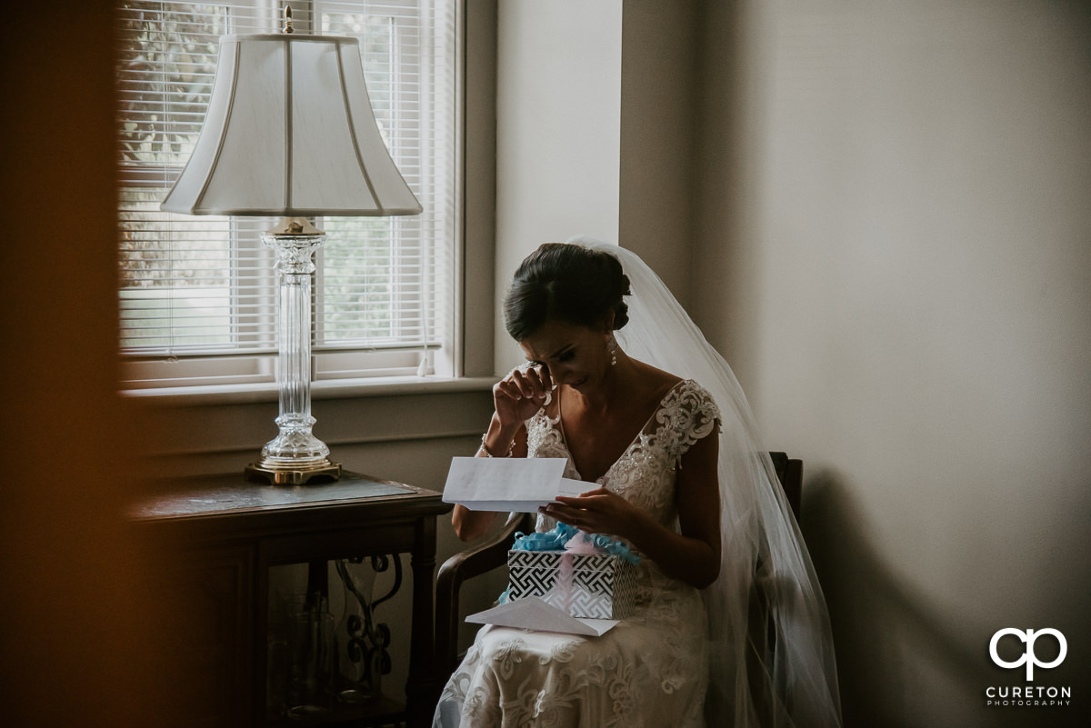 Bride tearing up while reading a letter from her groom before the wedding ceremony at Daniel Chapel.