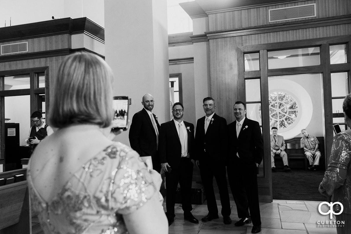Guest taking a photo of the groomsmen.