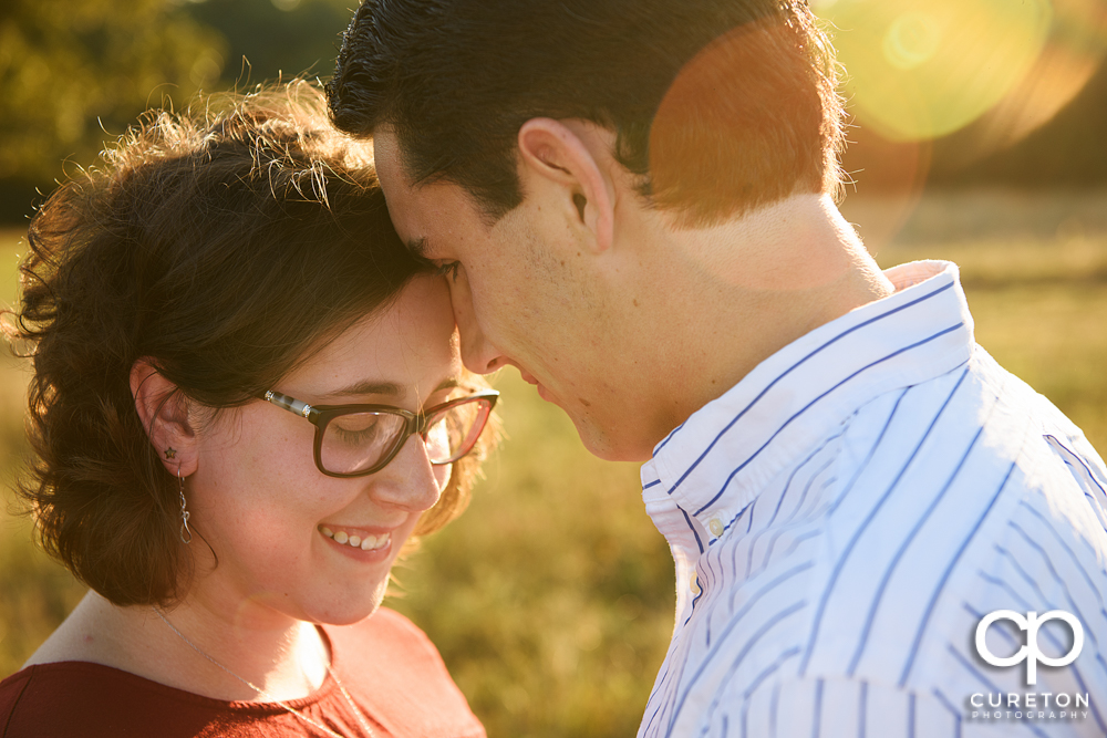 Engaged Couple standing in the sun during their engagement session at Greenbrier Farms.