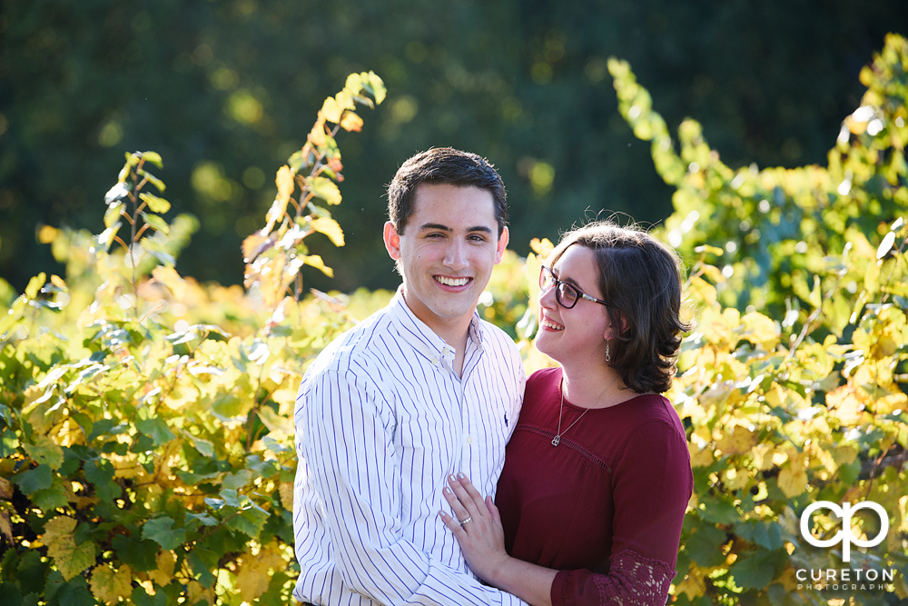 Future bride and groom laughing during their engagement session.