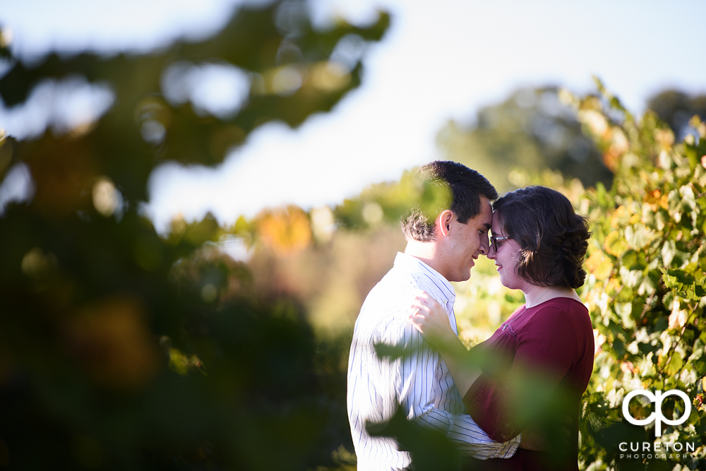 Engaged couple snuggling during their rustic engagement session near Greenville South Carolina.