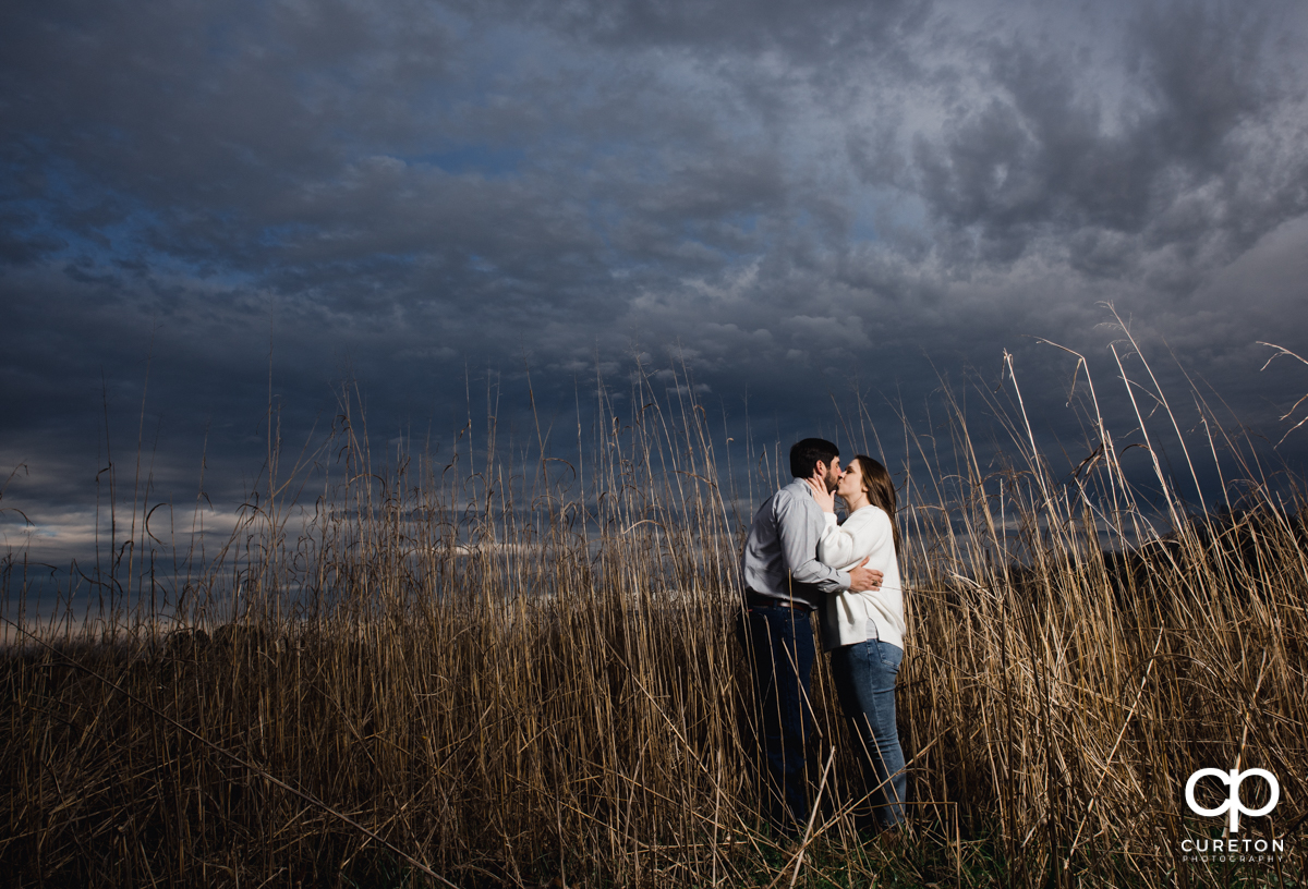 Bride kissing her fiancee in a field at Greenbrier Farms.