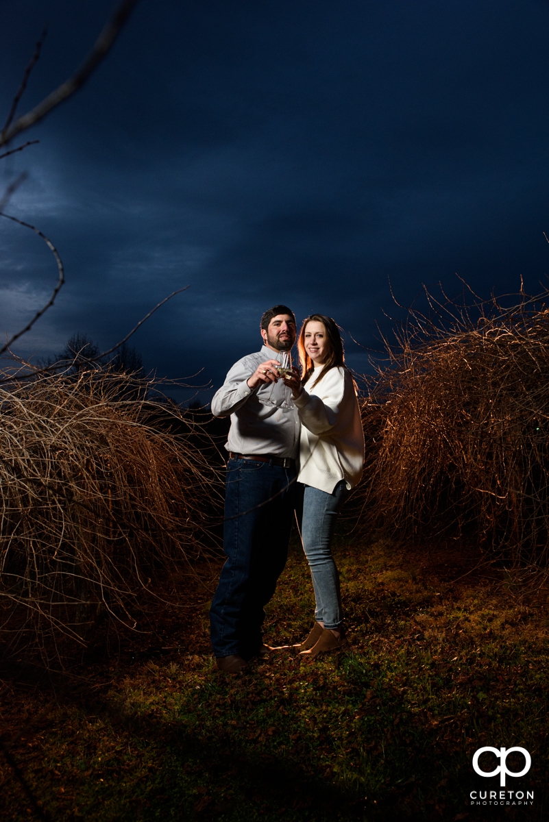 Engaged couple drinking some champagne in the vineyard at Greenbrier Farms during an engagement session.