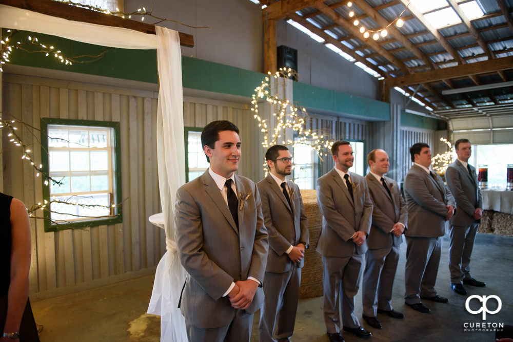 Groom sees his bride walking down the aisle for the first time.