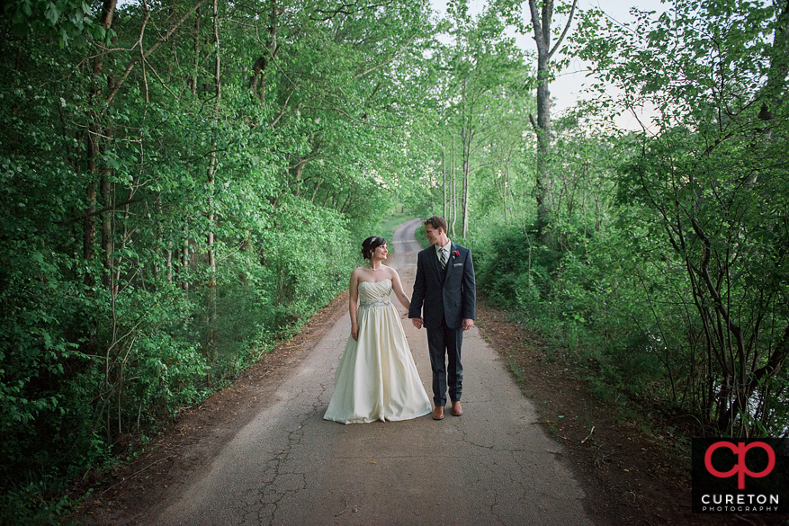 Bride and groom strolling down the road their Greenbrier Farms wedding.