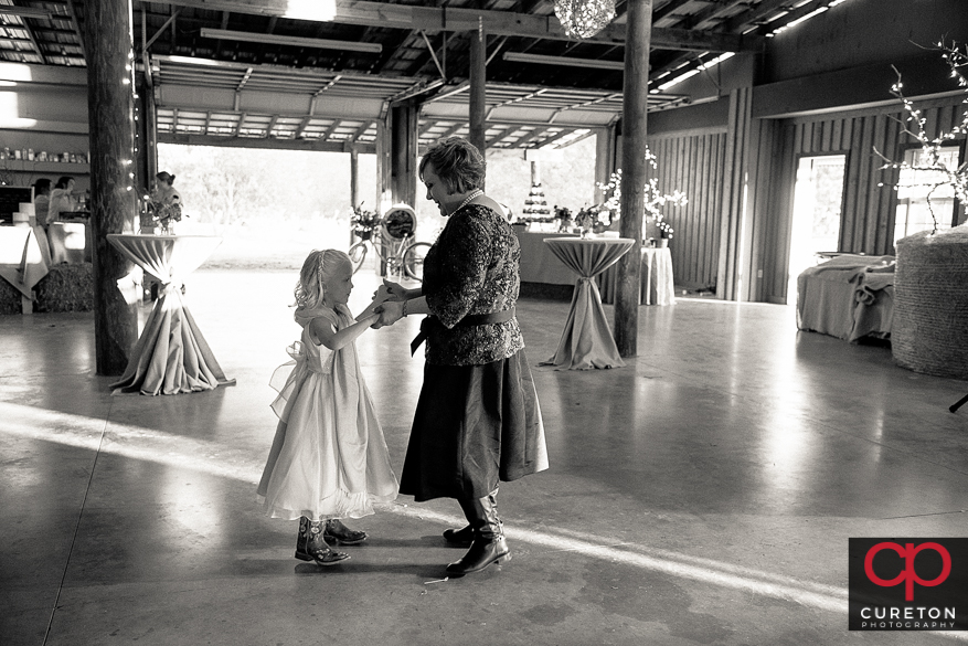 Bride's mom dancing with a flower girl.